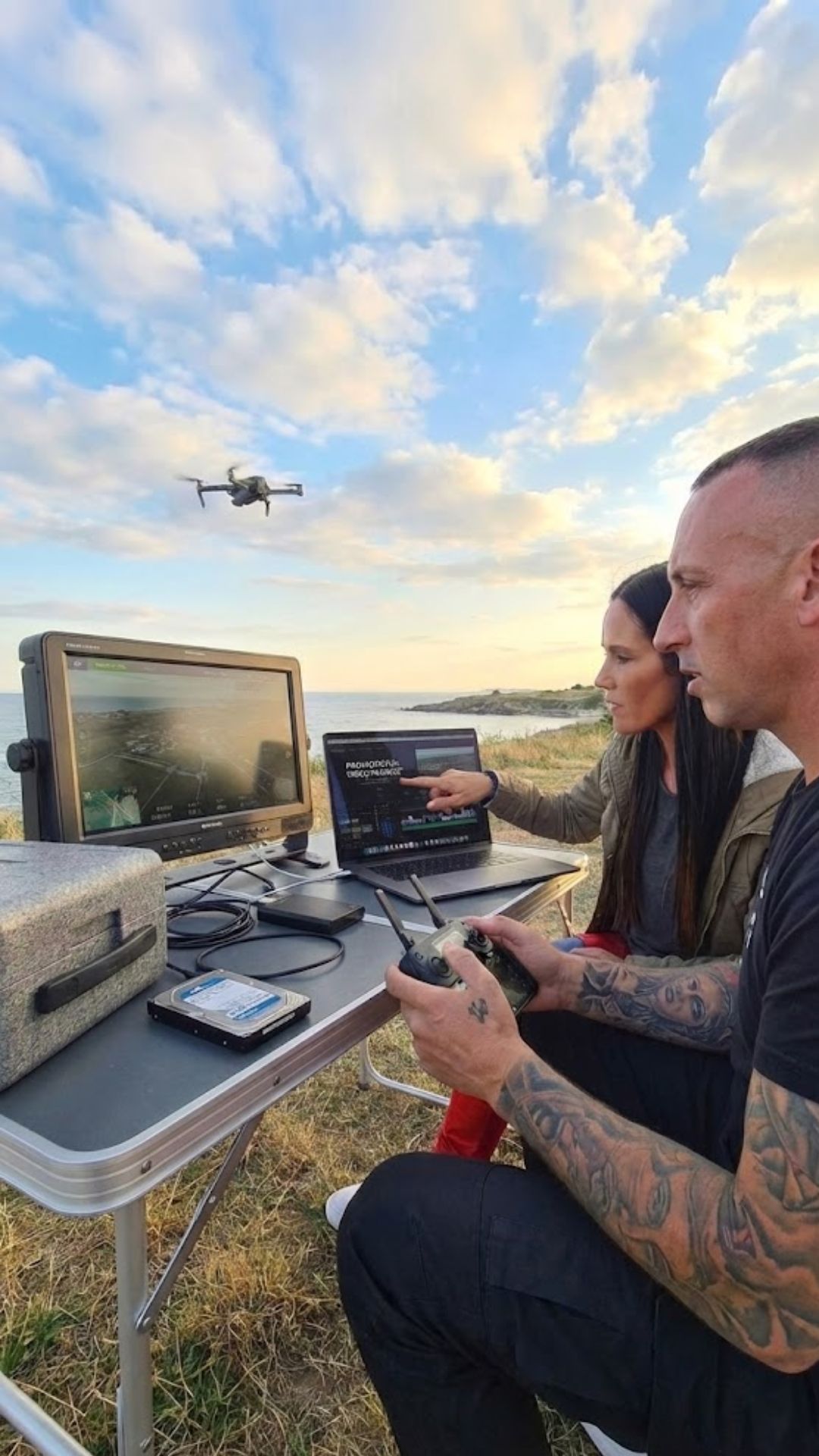 Drone pilot and editor reviewing cinematic aerial footage for promotional video production